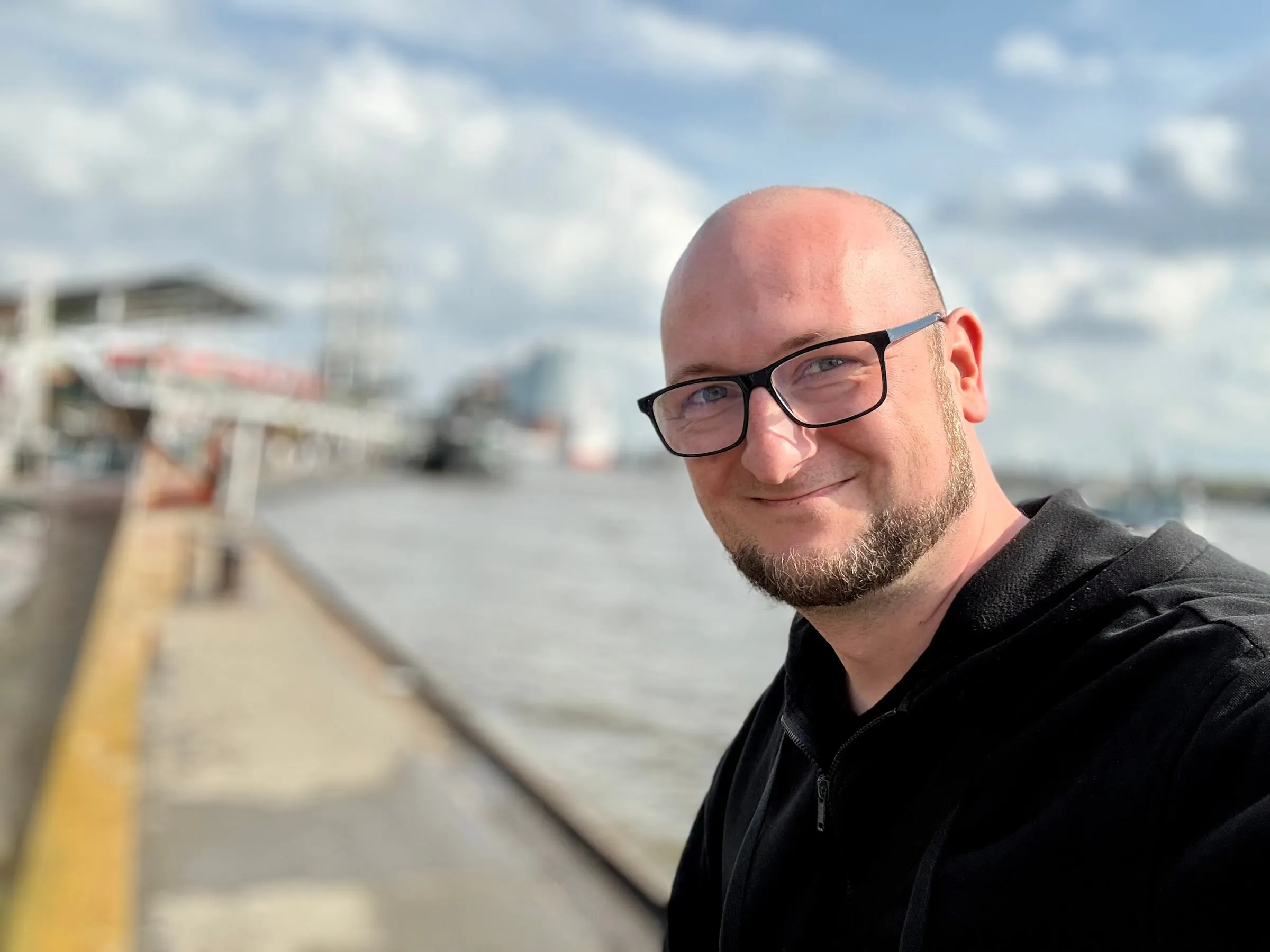 Selfie of Christoph Vollmann by the water, smiling into the camera